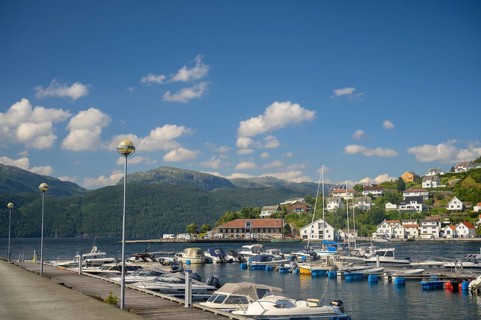 Sand, Rogaland municipality, Norway, harbour full of boats in front of a city with mountains in the