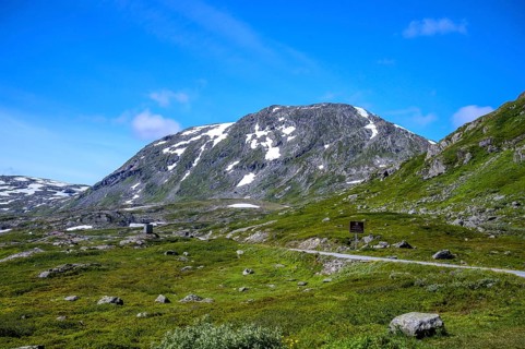 Geiranger, Møre og Romsdal province, Norway, rocky mountain landscape with green fields and blue