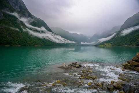 Olden, Vestland, Norway, Tranquil fjord landscape with mountains and cloudy sky, surrounded by