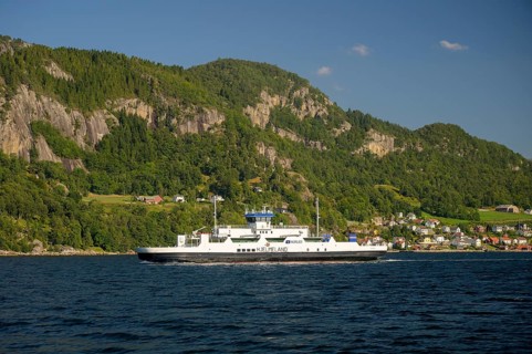 Hjelmeland, Rogaland Municipality, Norway, ferry on a fjord in front of a wooded landscape with