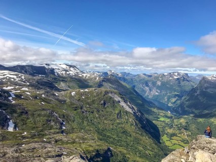 Geiranger, Møre og Romsdal province, Norway, panorama of mountains and green valley under blue sky