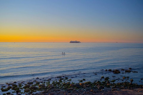 Hirtshals, Nordjylland region, Denmark, sunset over a calm sea with gentle waves and rocks on the