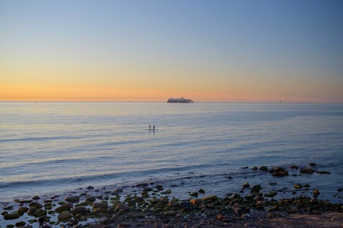 Hirtshals, Nordjylland region, Denmark, sunset over a calm sea with gentle waves and rocks on the