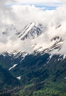 Fog sweeps around mountain peaks with remnants of snow, view from Slaughter Ridge Trail, Cooper
