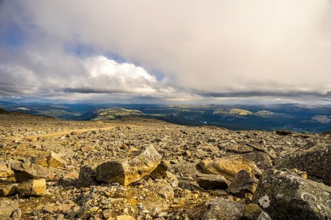 Alvdal, Innlandet, Norway, far-reaching view over a rocky landscape under a dramatic sky, road to