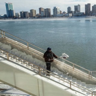 Detroit, Michigan USA - 15 January 2026 - A worker shovels snow from steps leading to Huntington