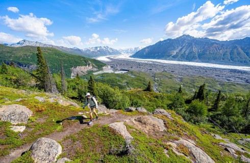 Young man on a hiking trail, view of impressive mountain landscape with Matanuska glacier and