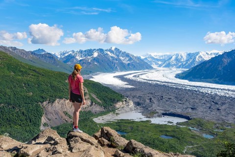 Young woman enjoying the view, view of impressive mountain landscape with Matanuska glacier and