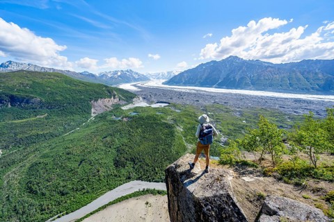 Young man on a rocky outcrop enjoying the view, view of impressive mountain scenery with Matanuska
