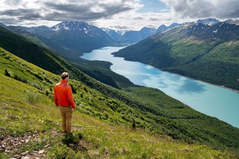 Mountaineer enjoys views of blue lake and mountains on Twin Peaks Trail, Eklutna Lake, Chugach