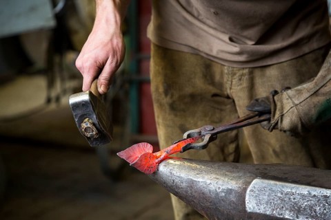 A blacksmith forging, working at the Ehnert forge in Dresden-Bühlau, Saxony, Germany