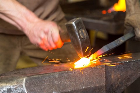 Sparks spray, a blacksmith forging, working at the Ehnert forge in Dresden-Bühlau, Saxony, Germany
