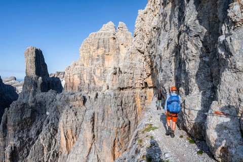 Two mountaineers on an exposed rock band in the secured Via Ferrata Bocciere Centrale via ferrata,