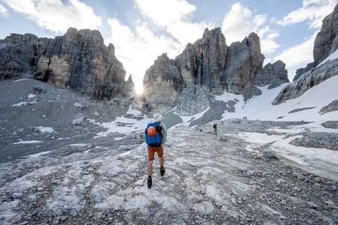Mountaineers climbing a rocky mountain landscape with steep rock peaks to Bocca degli Armi, Sun