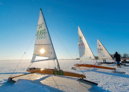 Ice sailboats on frozen Dümmer Lake in sunshine under clear sky, Lembruch, Dümmer nature park Park,