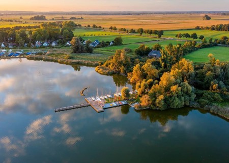 Drone view of Dümmer See with boats in a sailing harbor, surrounded by landscape with fields and
