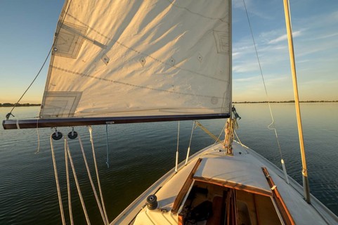 Sailing boat dinghy cruiser in evening light on the Dümmer See water, quiet nature and freedom,