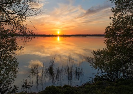 Sunset over a lake, colorful sky reflection, quiet scenery south bay of Lake Dümmer, Dümmer nature