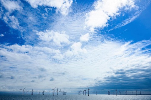 Wide landscape with offshore wind turbines from the Kriegers Flak 2 offshore wind farm under a blue