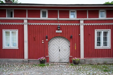 Street scene in the old town of Naantali, red historic wooden building with decorative windows on a