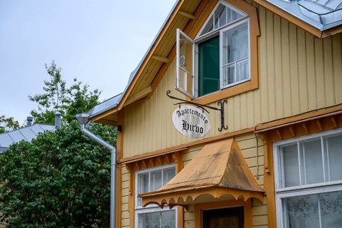 Street scene in the old town of Naantali, yellow wooden house with a rustic charm and a sign
