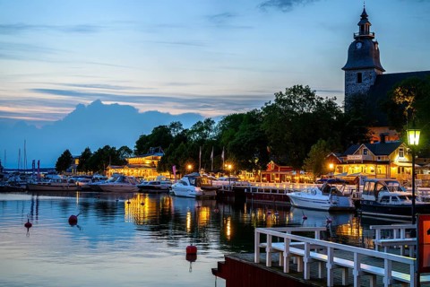 Street scene in the old town of Naantali, evening mood at the harbor with illuminated buildings and
