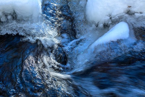 Ilsenburg, Saxony-Anhalt, Germany, Flowing water breaks through thick layers of ice in winter on