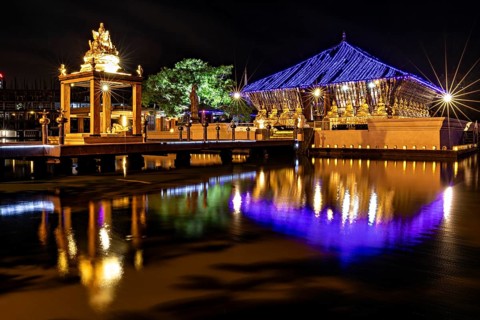 Night scene of an illuminated temple whose lights are reflected in the water, The Seema Malaka
