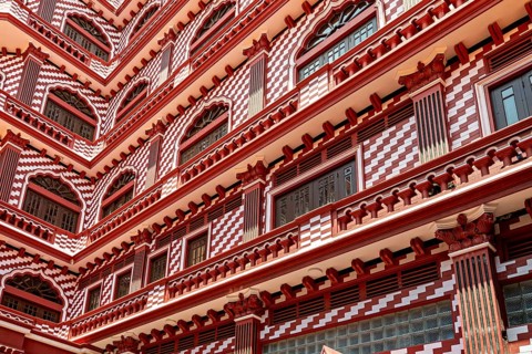 Detailed view of a red building façade with symmetrical window and pattern design, the old town