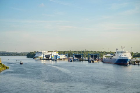 Large ferries and ships are moored at the port of Scandinavia Quay in Travemünde with deep blue