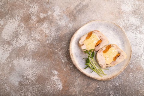 Chicken, egg and dried apricot meatloaf, microgreen on brown concrete background. top view, flat