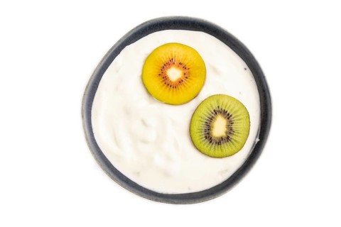 Yogurt, with kiwi in blue bowl isolated on white background, top view, flat lay, close up,