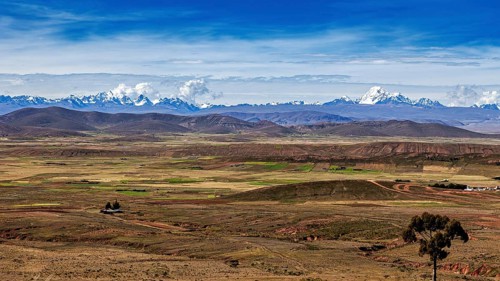 Extensive valleys in front of a high mountain range and deep blue sky, the Altiplano landscape in