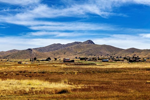 Wide fields and hills under a clear blue sky, The Altiplano landscape in the Andes of Bolivia