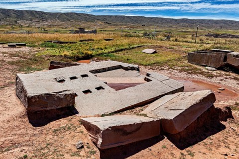 Large stone blocks and ruin structures on dry soil under a far-reaching sky, the archaeological