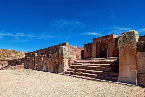 Broad view of ruins with stone entrances and stairs under clear skies, The archaeological site with