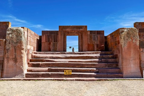 Stone architecture with stairs and entrance surrounded by ruins under blue skies, The