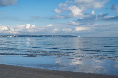 View across the Baltic Sea towards chalk coast, beach, sky with white clouds, Binz, seaside resort,