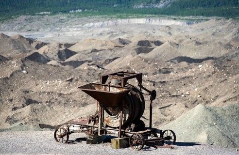 Old rusted moving mill for rock in front of mountain landscape with Kennicott Glacier, Historic