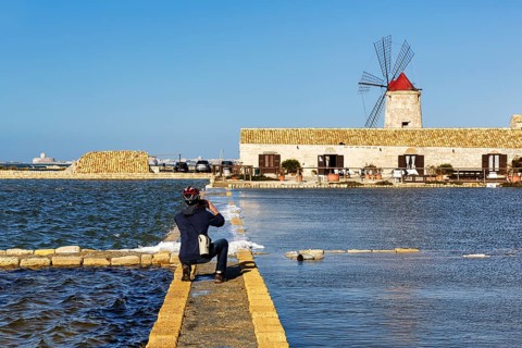Cyclist photographs salt museum, traditional windmill, saltworks di Trapani and Paceco nature