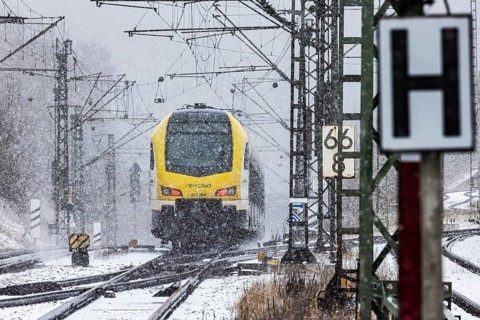Regional train from Arverio on its way through a winter landscape in snowfall. The railcar train is