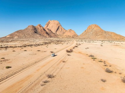 Car on sandy road, mountains in the desert, Spitzkoppe summit, Namib desert, Namibia