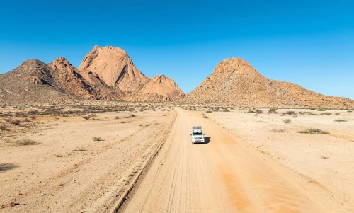 Aerial view, car on sandy road, mountains in the desert, Spitzkoppe summit, Namib desert, Namibia