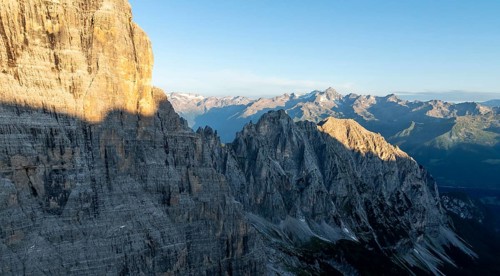 Aerial view, alpine panorama, rocky peaks at sunrise with alpine glow, picturesque mountain