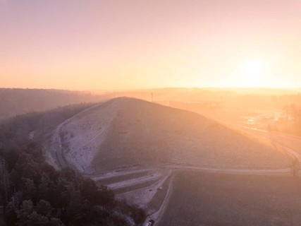 Natural hill in the soft light of a bright winter morning, old deposit, construction site for PV
