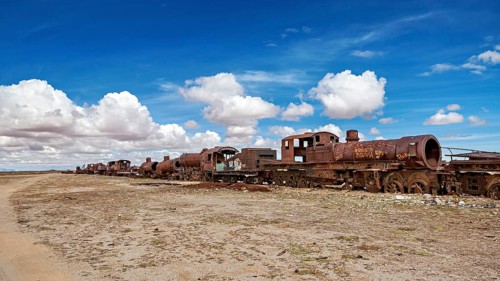 Row of abandoned, rusty locomotives in a desert-like environment, old rusty locomotives at the