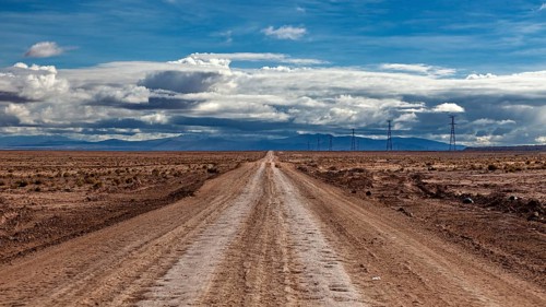 Lonely road stretching into the distance, under a cloudy sky, The landscape of the Altiplano near