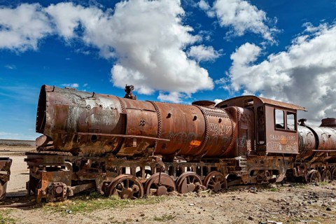 Rusty locomotive in a vast, cloudy and open landscape, old rusty locomotives at the train cemetery