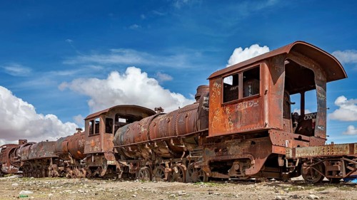 Rusted trains and locomotives in an abandoned area under blue skies, old rusty locomotives at the