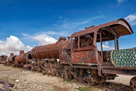 Close-up of a rusted locomotive with graffiti under a cloudy sky, old rusty locomotives at the